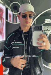 a man is taking a picture of himself in a mirror with gorrita de la tini written below him