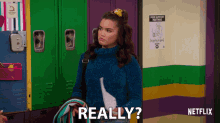 a girl in a blue sweater says really in front of a netflix sign
