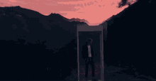 a man in a black jacket stands in front of a window