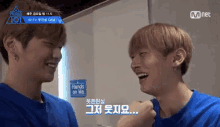 two young men are laughing in front of a sign that reads hands on me