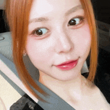 a close up of a woman 's face with red hair and brown eyes