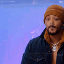 a man wearing a beanie and a denim jacket with the hashtag #exonthe beach