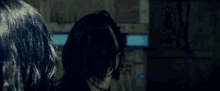 a woman is being punched in the face by another woman in a dark room