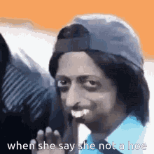 a man is wearing a hat and a blue shirt and says when she say she not a hoe