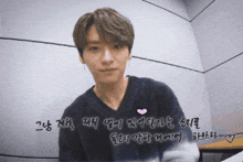 a man in a black sweater with a pink heart on his chest