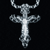 a silver cross with jesus on it is hanging from a chain