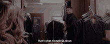 a man in a suit is talking to a woman in a clothing store