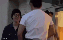 a man in a white shirt is standing next to another man in a black shirt