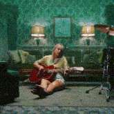 a woman is playing a guitar in a living room