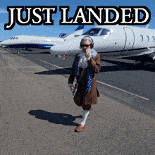 a man is standing in front of a plane with the words just landed above him