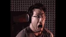 a man wearing headphones and glasses makes a funny face