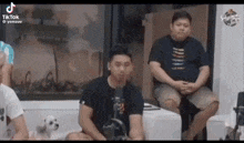 a group of people are sitting around a table with a dog and a microphone .