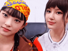 two girls are posing for a picture with one wearing a headband that says world