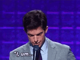 a man in a suit and tie is speaking into a microphone and saying 