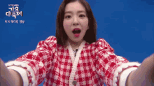 a woman in a red and white plaid dress is taking a picture