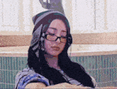 a woman wearing headphones and a beanie has a sticker on her hat that says ' nike ' on it