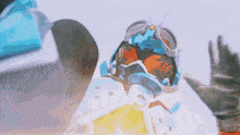 a person wearing a helmet and goggles is waving at someone