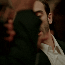a man in a suit is talking to another man
