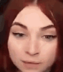 a close up of a woman 's face with red hair