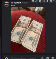 two 20 dollar bills are sitting on a red stool
