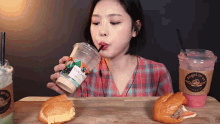 a woman is drinking from a cup that says angel mug on it