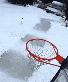 a basketball hoop is in the snow near a frozen lake