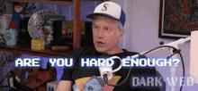 a man sitting in front of a microphone with the words are you hard enough written on the screen