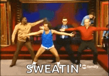 a group of men are dancing on a stage with the words sweatin ' written on the screen .