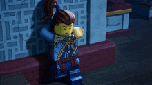 a lego figure stands in front of a wall with chinese writing on it