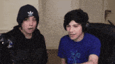 two young men wearing headphones and a beanie with adidas on it