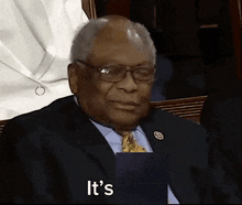 a man in a suit and tie is holding a piece of paper and says it 's .