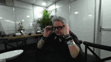 a man sitting at a table with a wristband that says ' i love you '