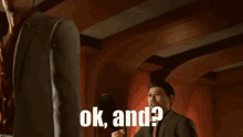 a man in a suit is holding a bottle in his hand and says ok and