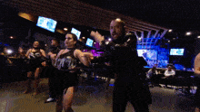 a man and a woman are dancing in a dark room with a sign that says exit on it