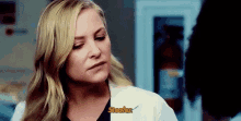 a woman in a lab coat is talking to a man in a hospital room .