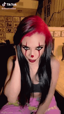 a woman with red hair is wearing a clown costume .