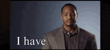 a man in a suit and polo shirt is making a funny face and saying i have .
