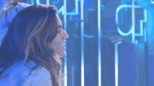 a woman is smiling in front of a neon sign that says ' cp '