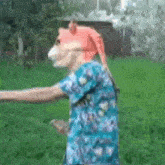 a person wearing a fox mask is standing in a field .