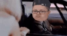 a man in a suit and tie is sitting in a car .