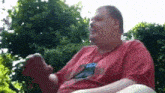 a man wearing a red shirt with a blue dolphin on it