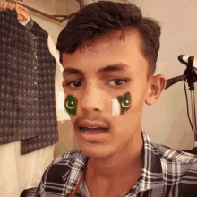 a young man with a green and white flag on his face