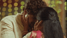a man and a woman are kissing and the woman is touching the man 's forehead