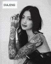 a black and white photo of a woman with tattoos on her arms and the words diajeng above her