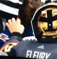 a person wearing a jersey that says fi fury holds another person 's hand
