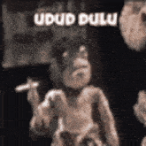 a monkey is smoking a cigarette in a black and white photo with the words udud bulu written on it .