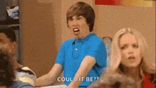 a man in a blue shirt is making a funny face while sitting at a table with a woman .