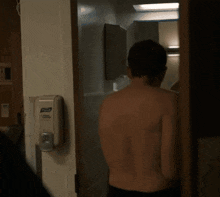a shirtless man is standing in a hospital room .