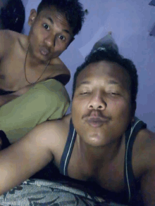 two shirtless men are posing for a picture and one has a mustache