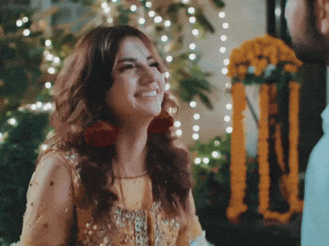 a woman in a yellow dress smiles in front of a man